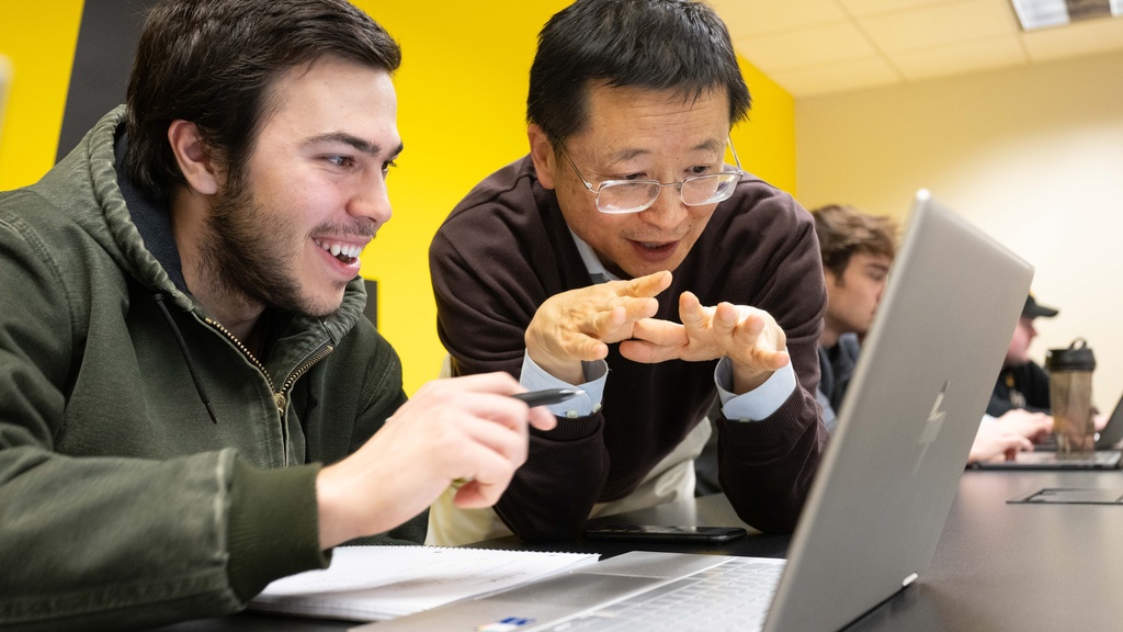 Faculty and student looking at laptop
